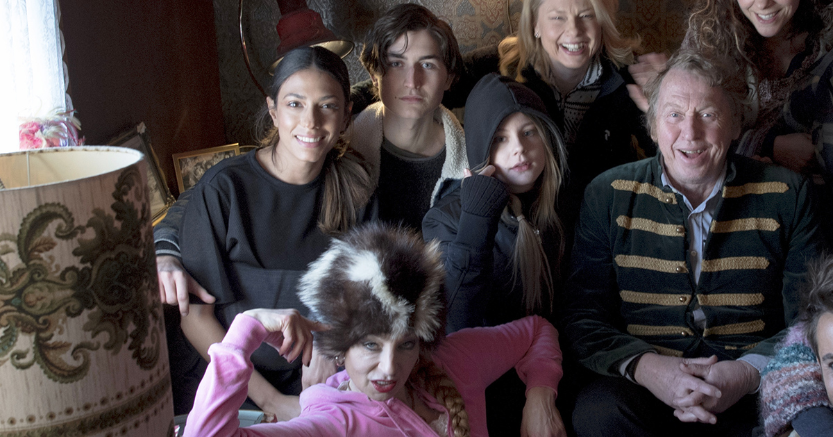 Leende människor i och vid en soffa.