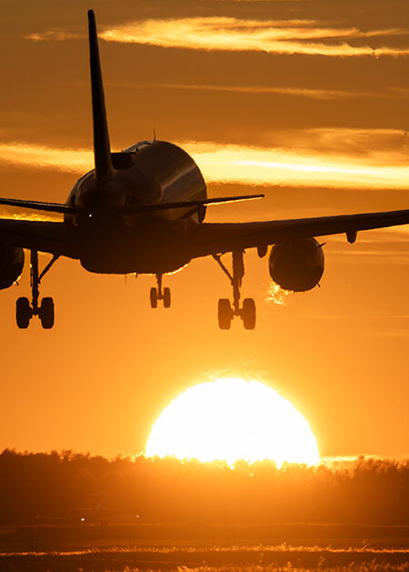 Flygplan landar i solnedgång.