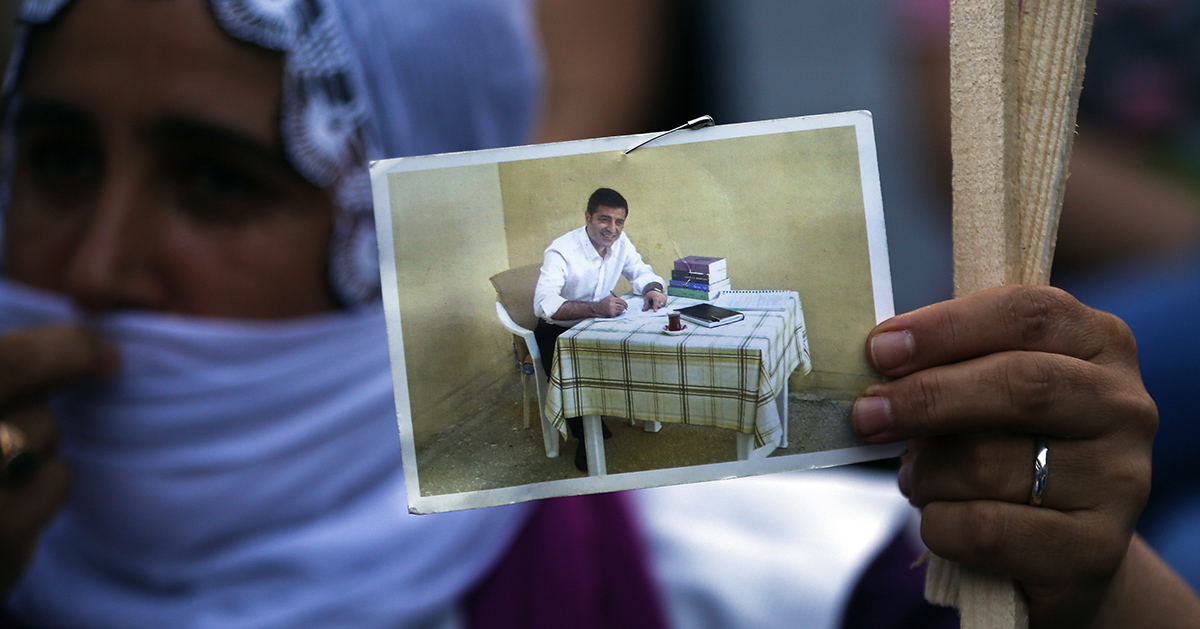 En kvinna håller upp ett foto av en man.