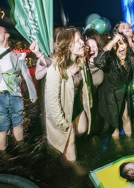 Glada ungdomar badar i fontän.