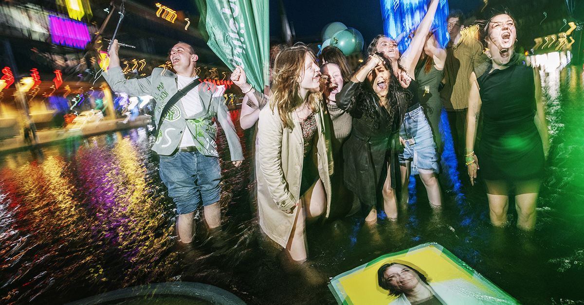 Glada ungdomar badar i fontän.