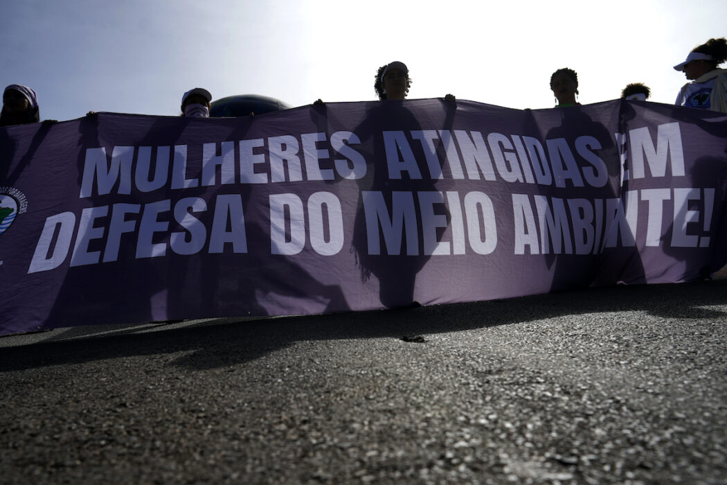 kvinnor bär banderoll med texten Kvinnor som drabbats i kampen för miljön