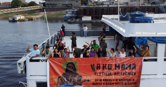 Människor på en båt med ett plakat.