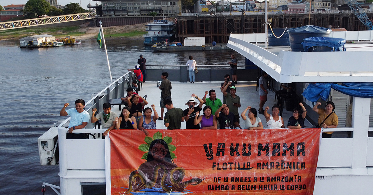 Människor på en båt med ett plakat.