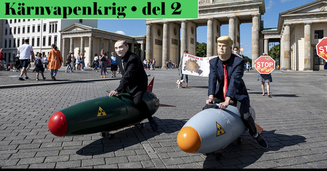 Putin och Trump i papier maché leker med atombombsmodeller på ett torg.