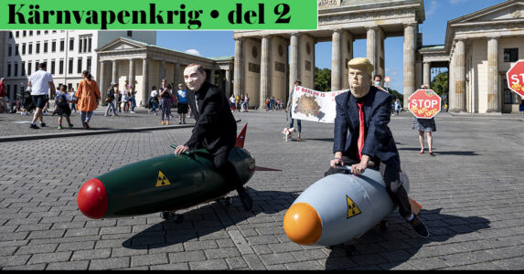 Putin och Trump i papier maché leker med atombombsmodeller på ett torg.