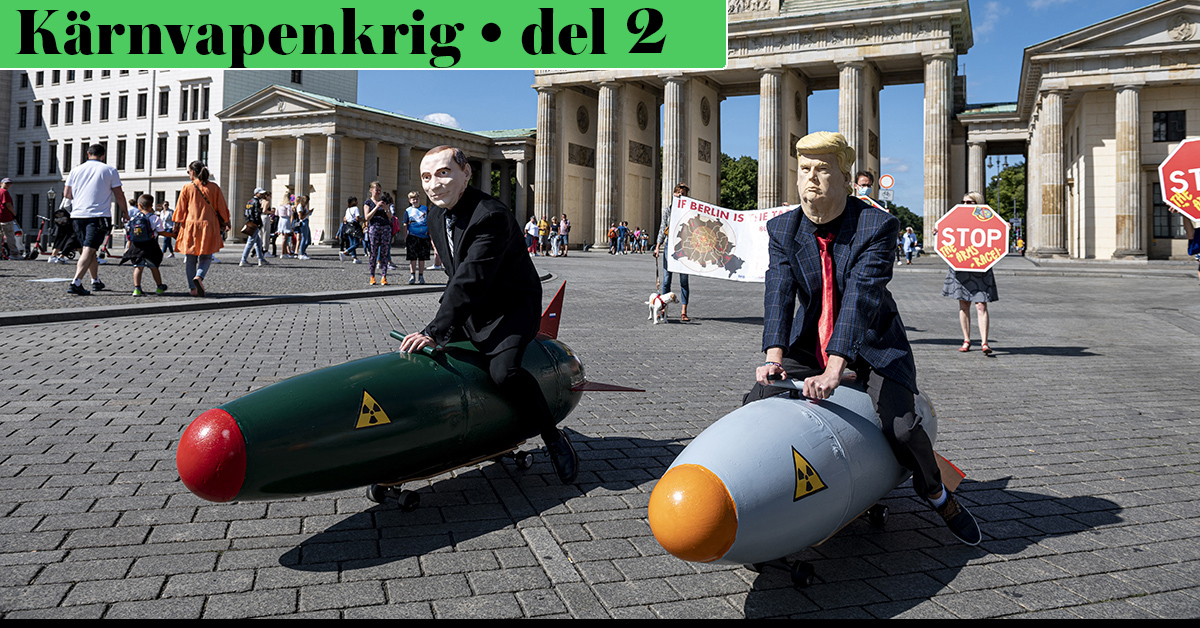 Putin och Trump i papier maché leker med atombombsmodeller på ett torg.