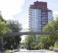 höghus, gångbro och människor, träd