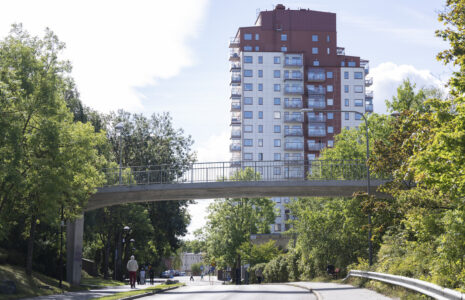 höghus, gångbro och människor, träd