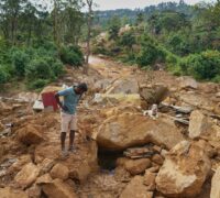 En man tittar på förstörelsen efter ett jordskred.