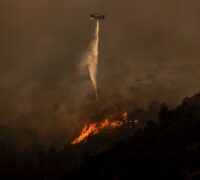 En helikopter försöker släcka en brand.