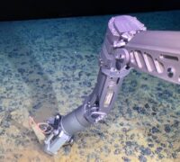 Robotarm som sträcker sig mot polymetalliska noduler i djuphavet.