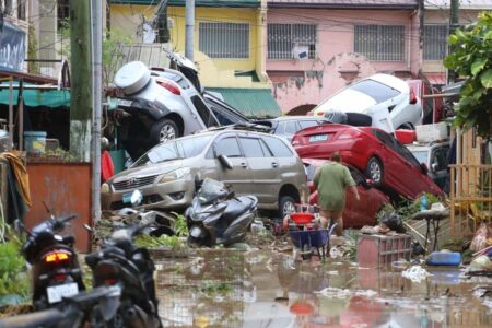 Översvämning i Filipinnerna. Bilar och bråte.