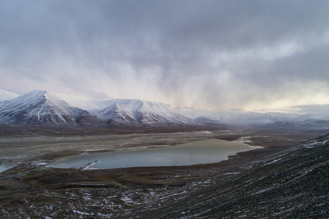 berg med snö på toppen, sjö i en dal