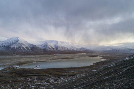 berg med snö på toppen, sjö i en dal