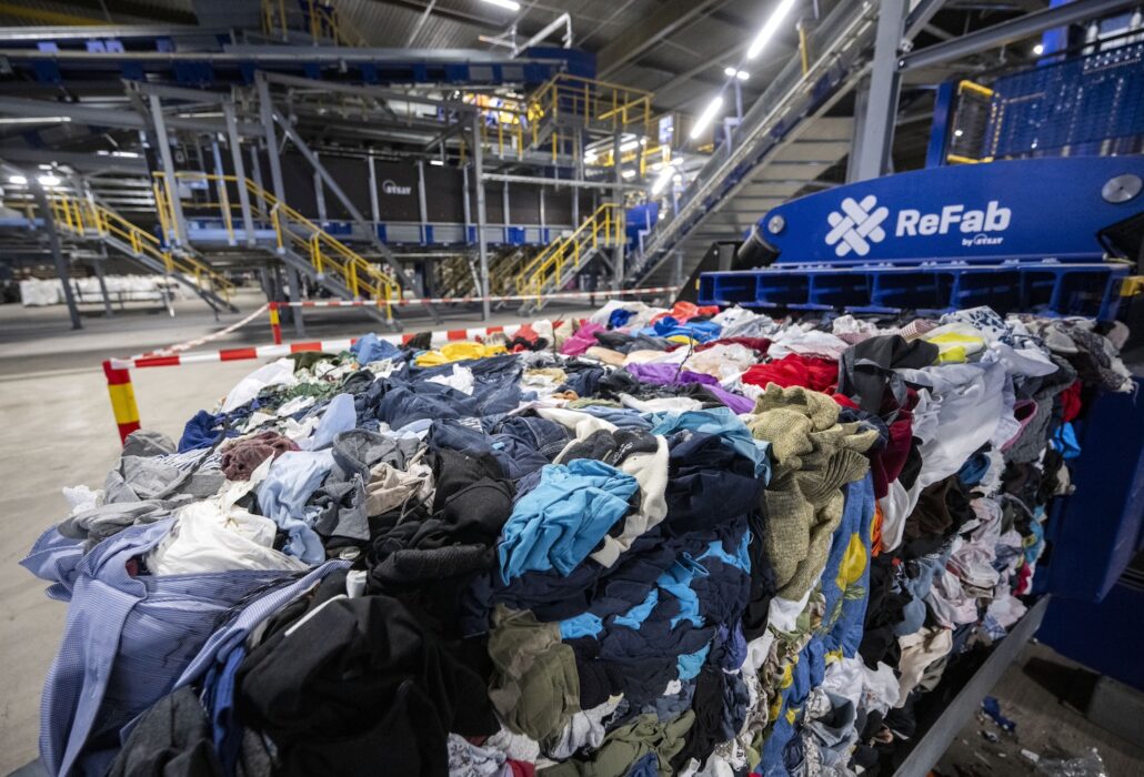 Kläder framför en sorteringsmaskin.