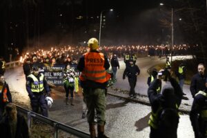 Personer marscherar med facklor.