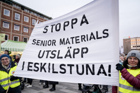 Demonstranter håller upp banderoll med texten Stoppa Senior materials utsläpp i Eskilstuna!