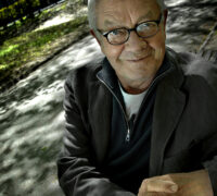 En leende man i trädskugga.