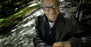 En leende man i trädskugga.