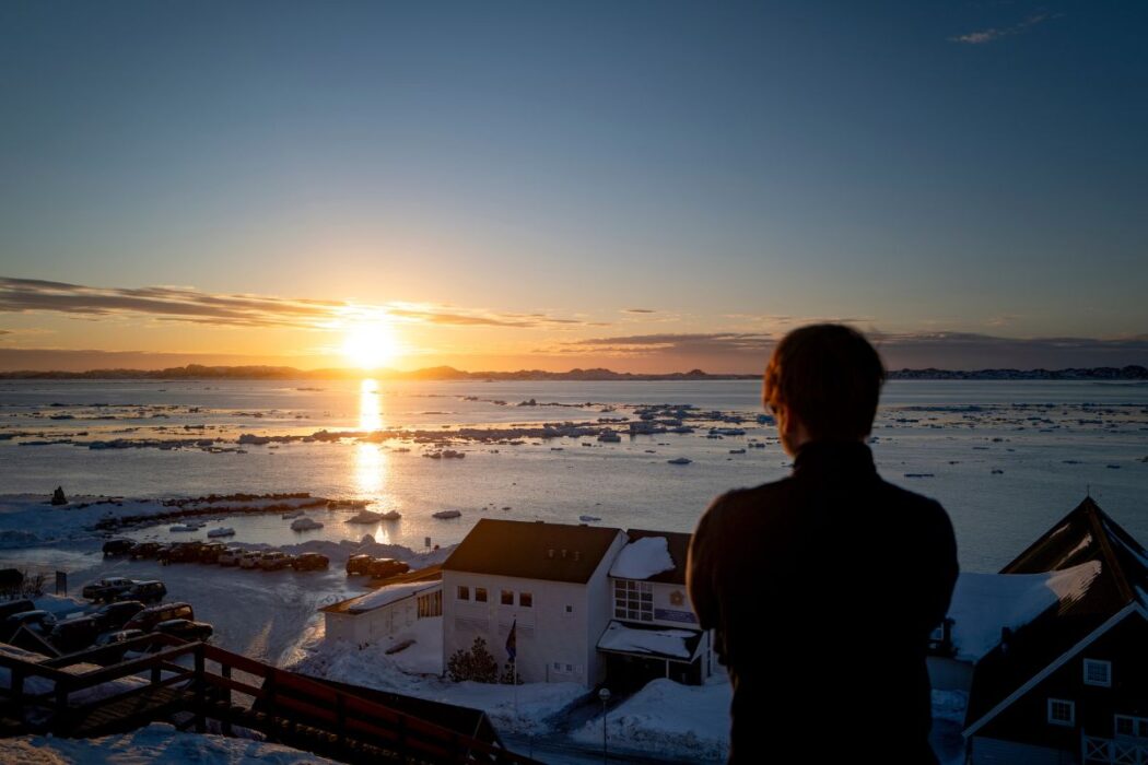 En person blickar ut över norra ishavet på Grönland.