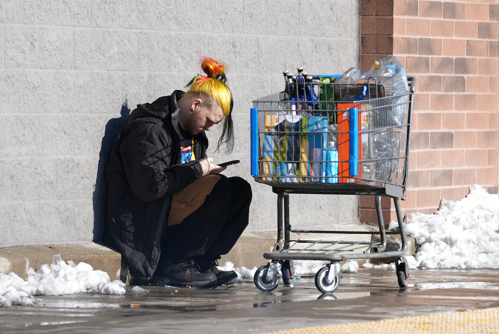 ung man med färgat hår och shoppingvagn