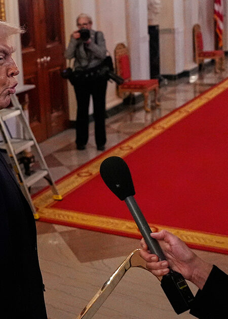 Donald Trump går förbi en journalist med mikrofon.