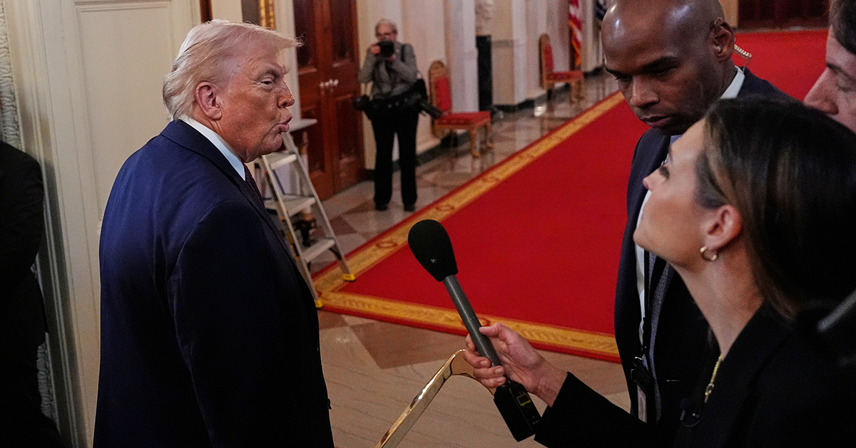 Donald Trump går förbi en journalist med mikrofon.