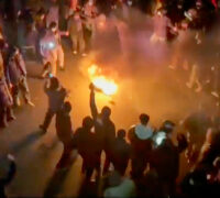 Demonstranter dansar vid en eld.