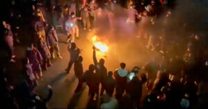 Demonstranter dansar vid en eld.