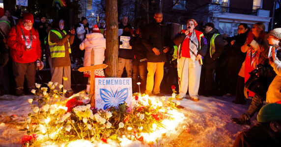 Människor samlas kring blommor och ljus för en mördad kvinna.
