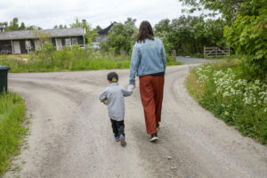 mamma går med barn på väg