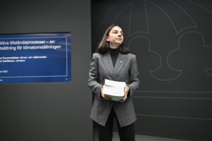 Romina Pourmokhtari med tre böcker av utredning i händerna.