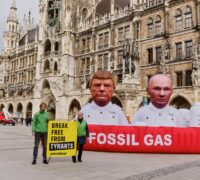 Aktivister med banderoll och två stora bilder på Donald Trump och Vladimir Putin.