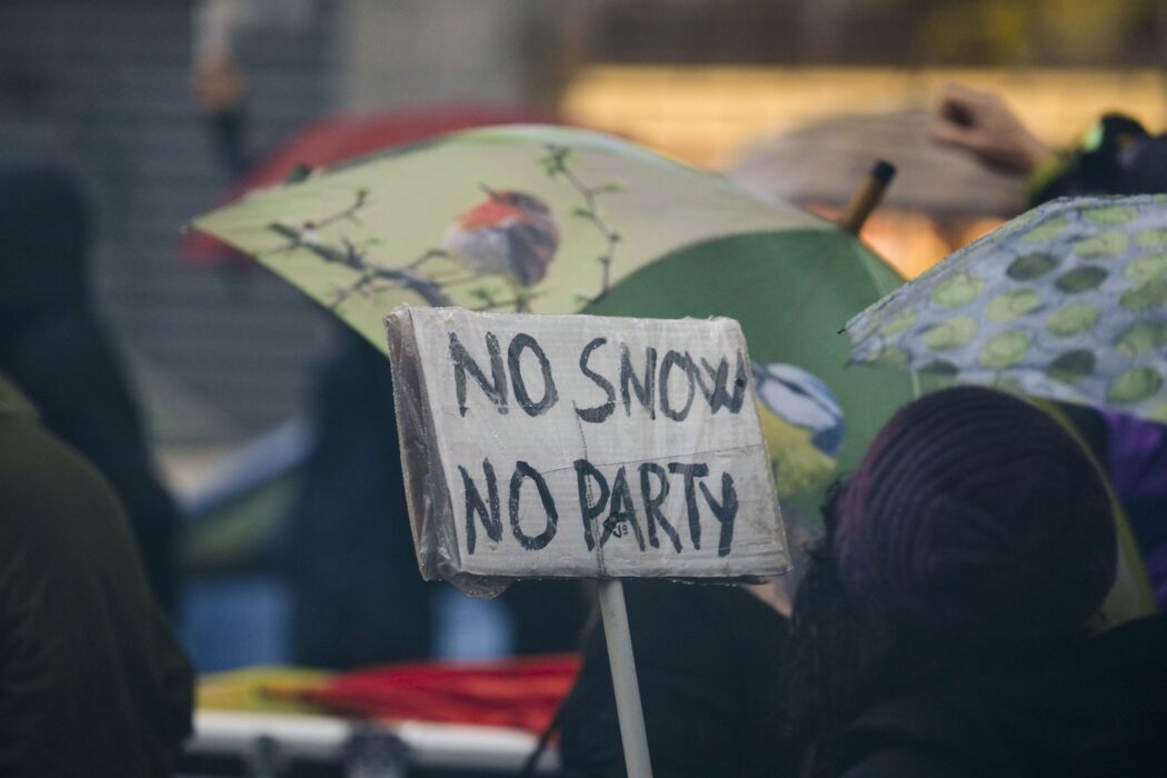 Protestskylt som lyder: No snow, no party.