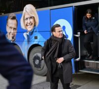 Ulf Kristersson framför valturnébuss.