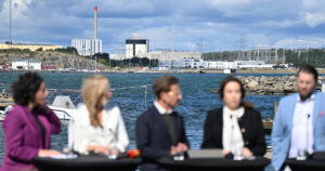 Fem suddiga personer framför en havsvik.