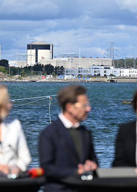 Fem suddiga personer framför en havsvik.