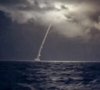 En raket skjuts upp över havet i mörker.