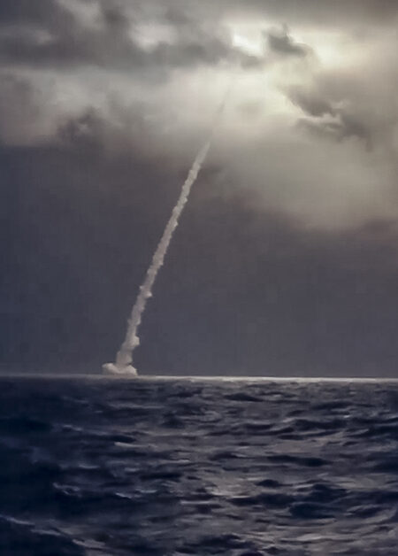 En raket skjuts upp över havet i mörker.