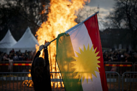 Kurdistans flagga framför eld.