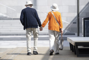 ett äldre par på promenad som håller varandra i handen