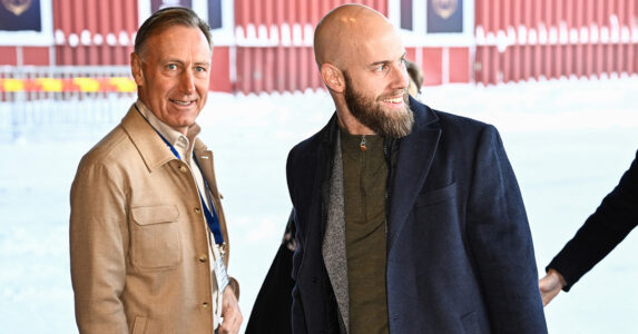 Två män i snö utanför ett hus.