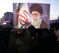 Ayatolla Khameneis bild syns på ett plakat i en folkmassa.