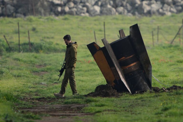 Soldat strå bredvid fragment av en oexploderad missil.