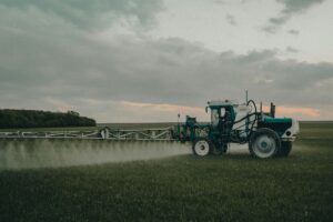 Traktor som besprutar ett fält.