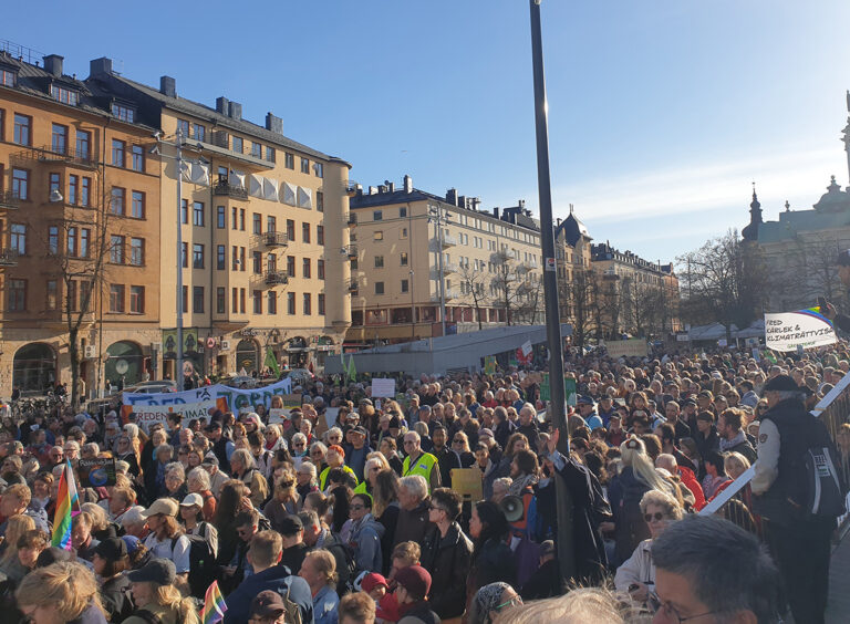 Folkmassa på torg, sol