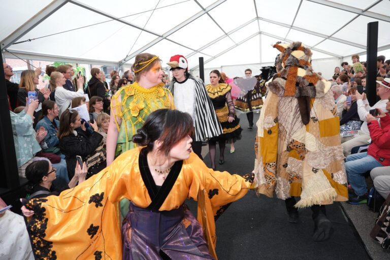 Catwalk med personer utklädda till olika arter.