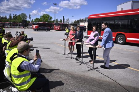 Presskonferens vid en bussdepå.