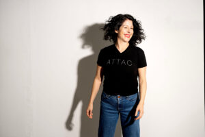 America Vera Zavala mot vit bakgrund, leende, t-shirt med ordet Attac